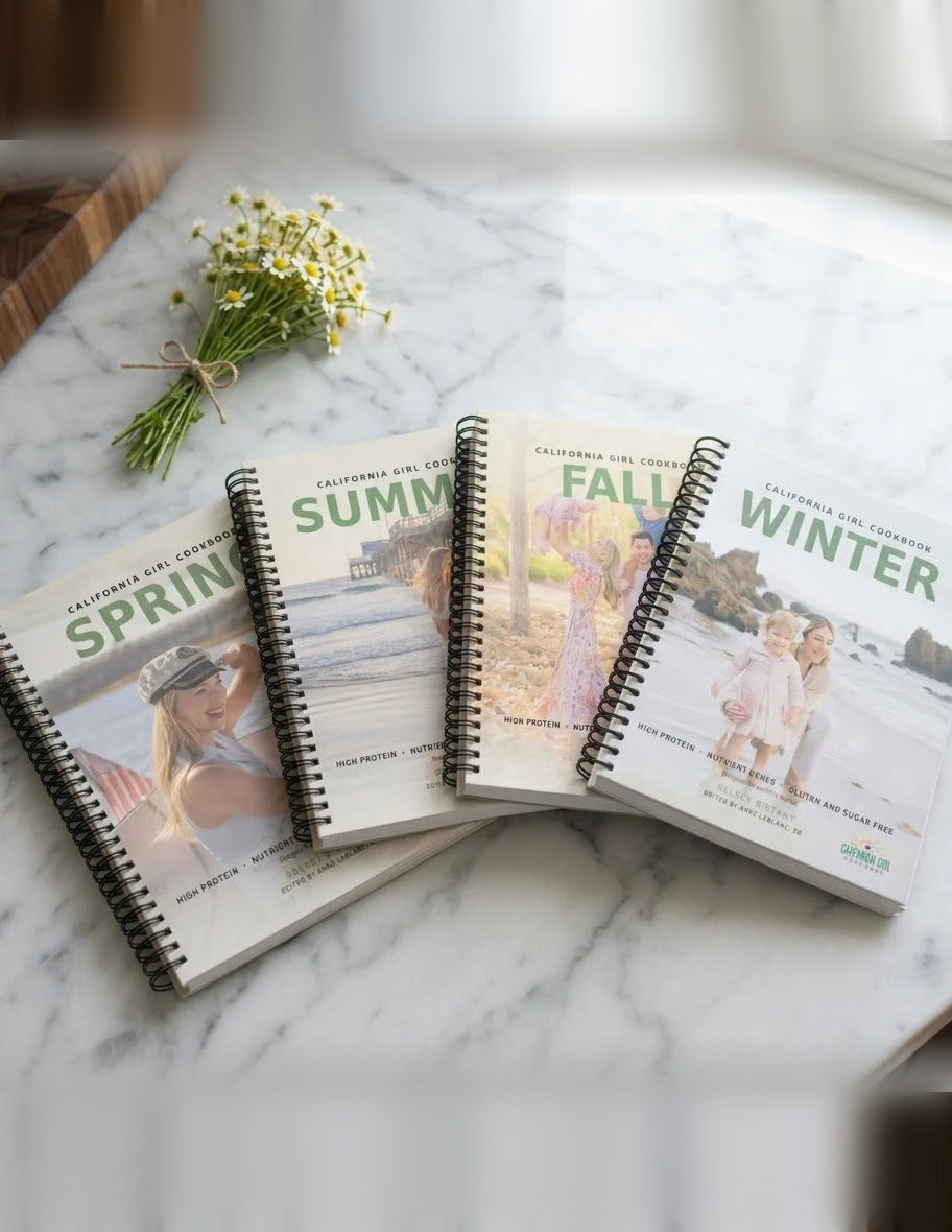 All 4 California Girl Cookbook seasonal spiral-bound cookbooks on marble countertop